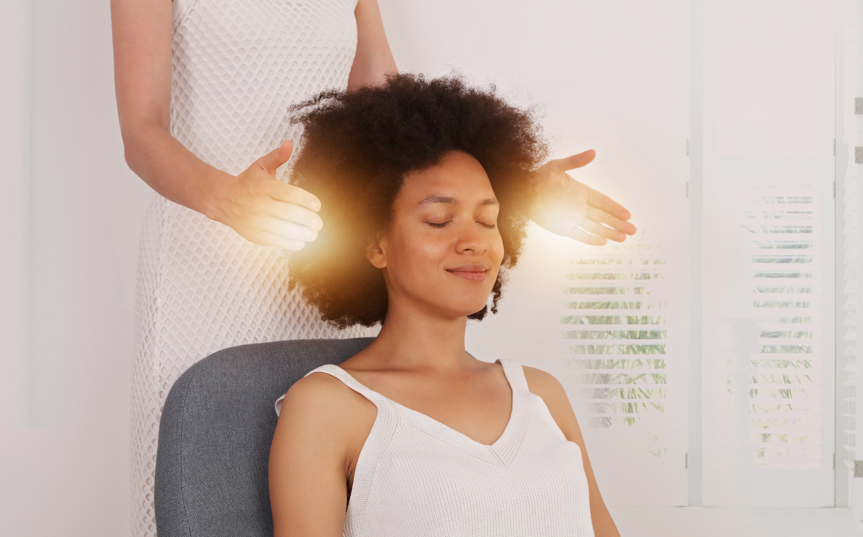 Reiki healer doing holistic treatment to young woman. Energy Chakra balancing